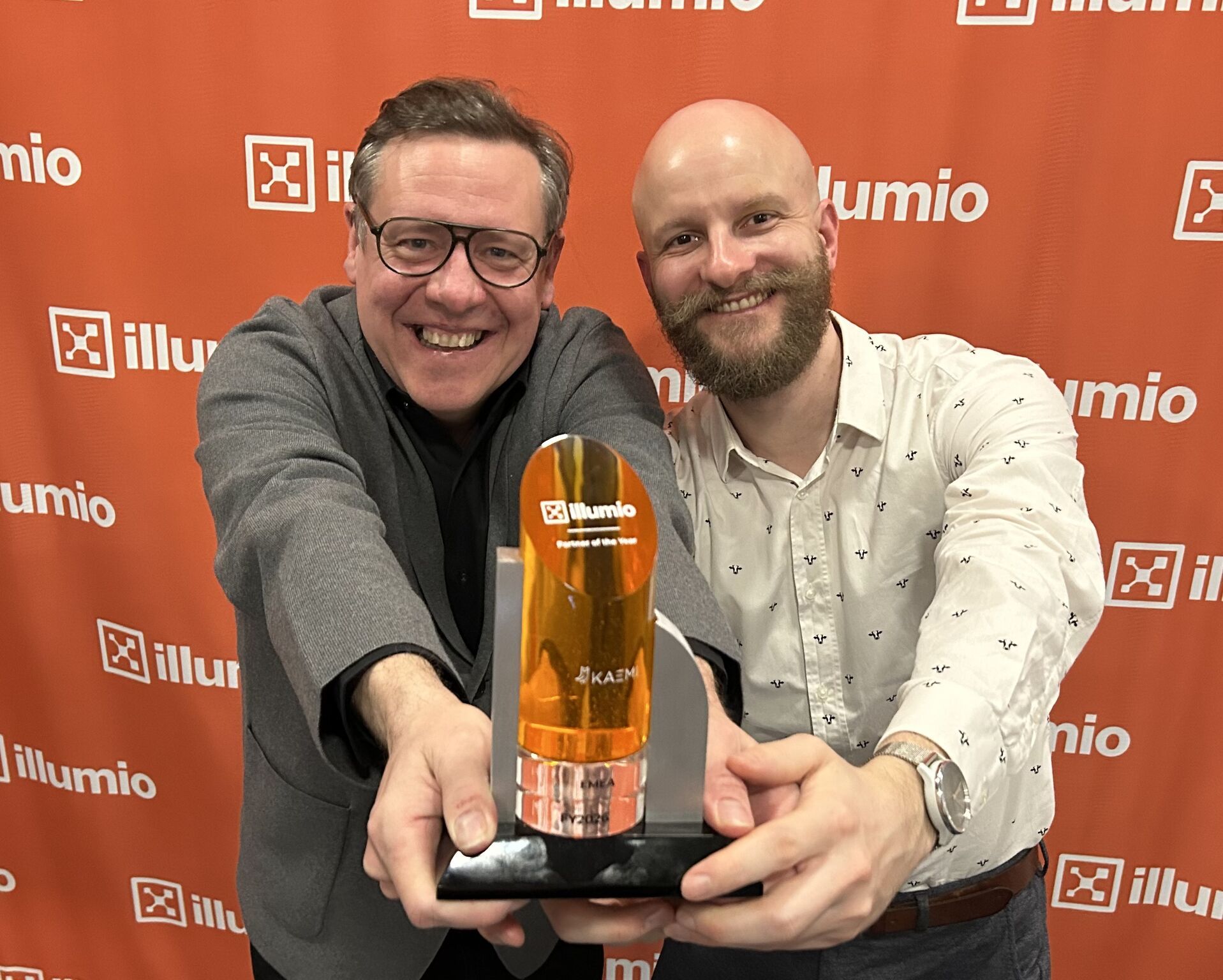 Die Trophäe „Illumio EMEA Partner of the Year" wird strahlend in die Kamera gehalten